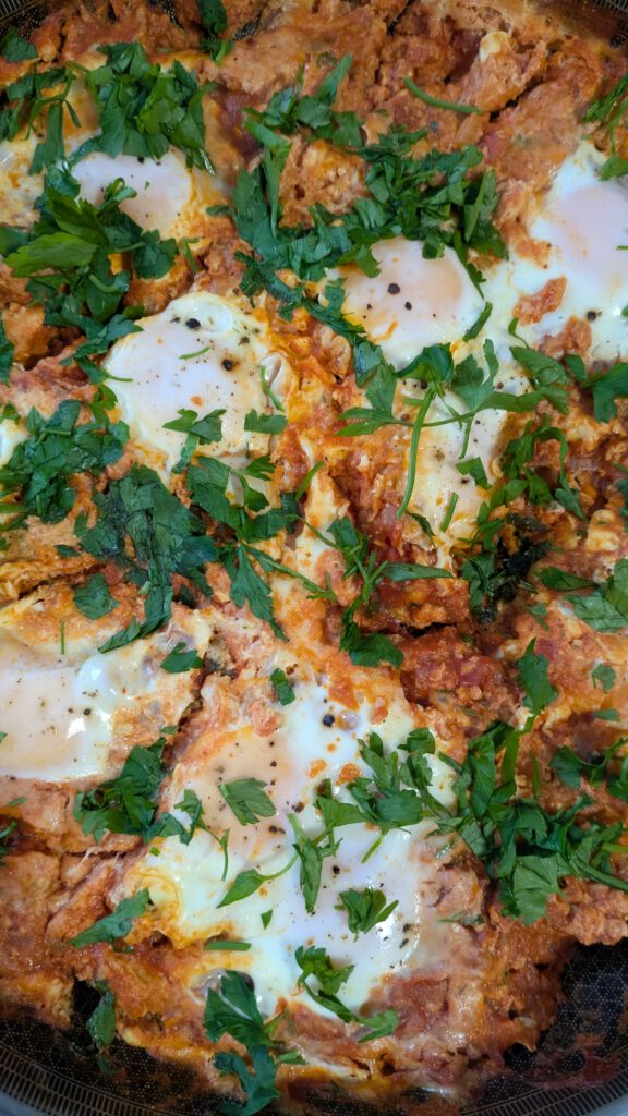 Perspektive von Oben in ein Abendessen, Shakshuka ein Gericht aus Tomaten mit poschierten Eiern